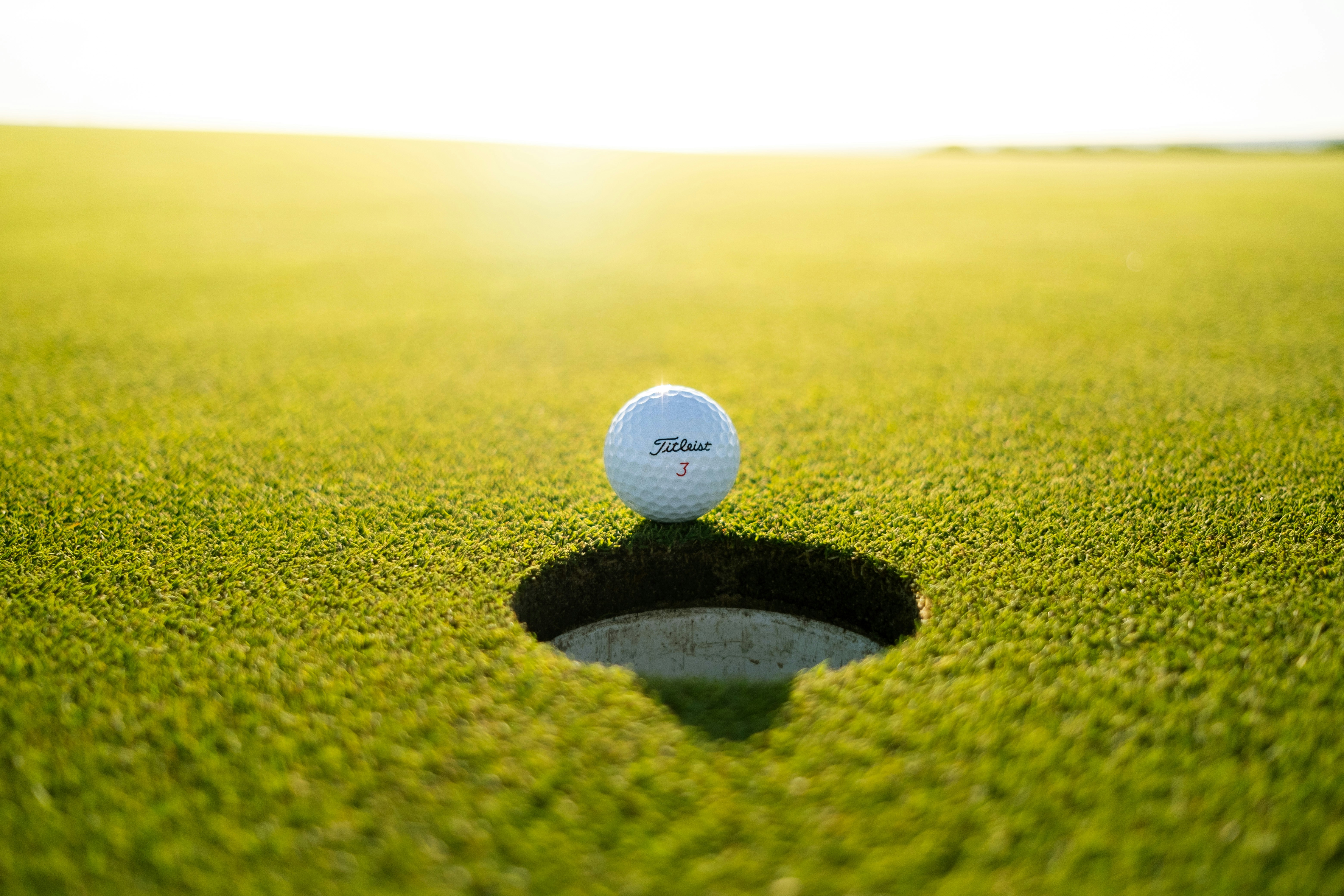 Golf ball on edge of hole